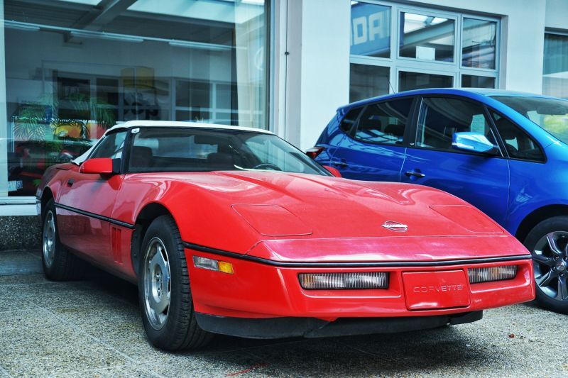 Rote Corvette vor dem Autohaus Oppitzhauser von vorne und Beifahrerseite aus betrachtet